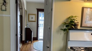 A kitchen with a checkered floor, a stove, and a door leading to a hallway with wooden flooring and a view of the outside. - OCNJ Gold Coast beach home, Pet friendly, 9 houses from the beach and boards!  (Ocean City)