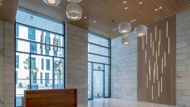 A spacious lobby with large windows, a wooden reception desk, and a modern ceiling design. - Magical 3BR/Parking with amazing view, city center (Jerusalem)