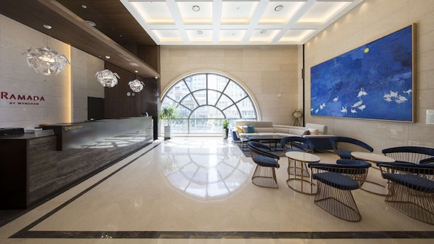 A modern reception area with a reception desk, seating area, and a large window.