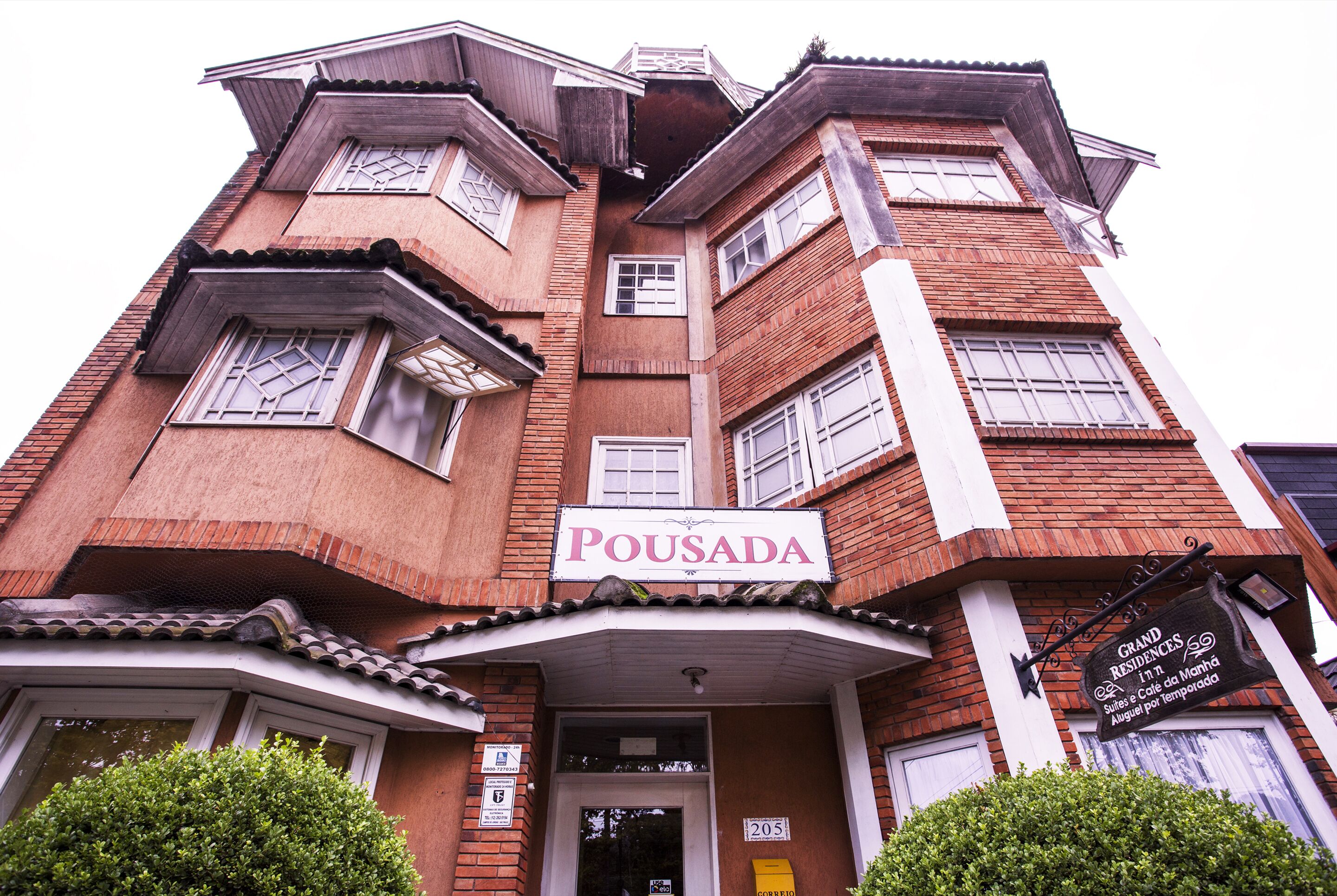 Monikerroksinen rakennus, jossa on kyltti, jossa lukee ”Pousada”, ja toinen kyltti, jossa lukee ”Grand Residences Suites & Cafe de Mano”.