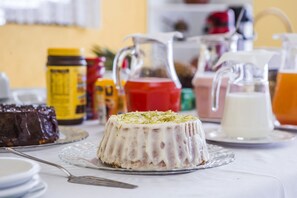A dessert on a glass plate with a spoon, surrounded by various food items and containers on a table. - Grand Residences Pousadas (Campos do Jordão)