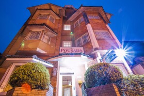A hotel named Pousada with a prominent entrance, a signboard, and well-maintained landscaping.