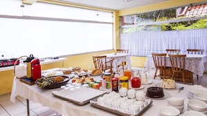 Un espace repas avec une table mise pour un repas, comprenant divers aliments et ustensiles.