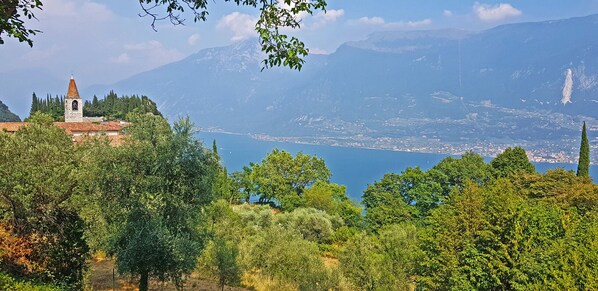 Un paysage montagneux avec une église, une végétation luxuriante et un lac.