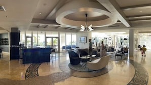 A spacious lobby with a central seating area, a reception desk, and large windows allowing natural light. - ★★★★★ Hotel 1 Bedroom Suite with ocean view ! Lic :STR-01360 Minimum 3 months.  (Sunny Isles Beach)
