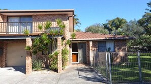 Stylish two-story home with a garage, garden, and metal fence.