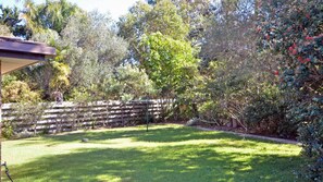 Enjoy an and natural outdoor space surrounded by lush greenery and a wooden fence.