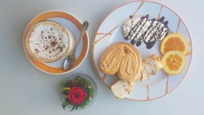 Ein Tisch mit einer Auswahl an Gebäck, einer Kaffeetasse und einer kleinen Dekoration.