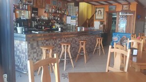Eine Bar mit Sitzhocker, einer Theke mit verschiedenen Flaschen und einer Ausstellung von Nestlé-Eis.