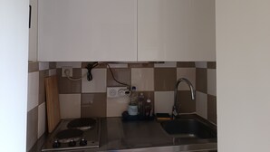 A kitchen with a stove, sink, and cabinets. - Studio 2 Pers. Pines View in Building Facing sea Baie de La Baule (La Baule-Escoublac)