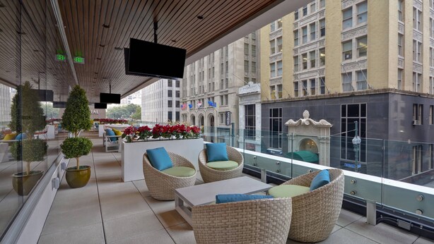 A rooftop lounge with wicker furniture, potted plants, and a large TV screen. - Residence Inn by Marriott New Orleans French Quarter Area/Central Business District (New Orleans)