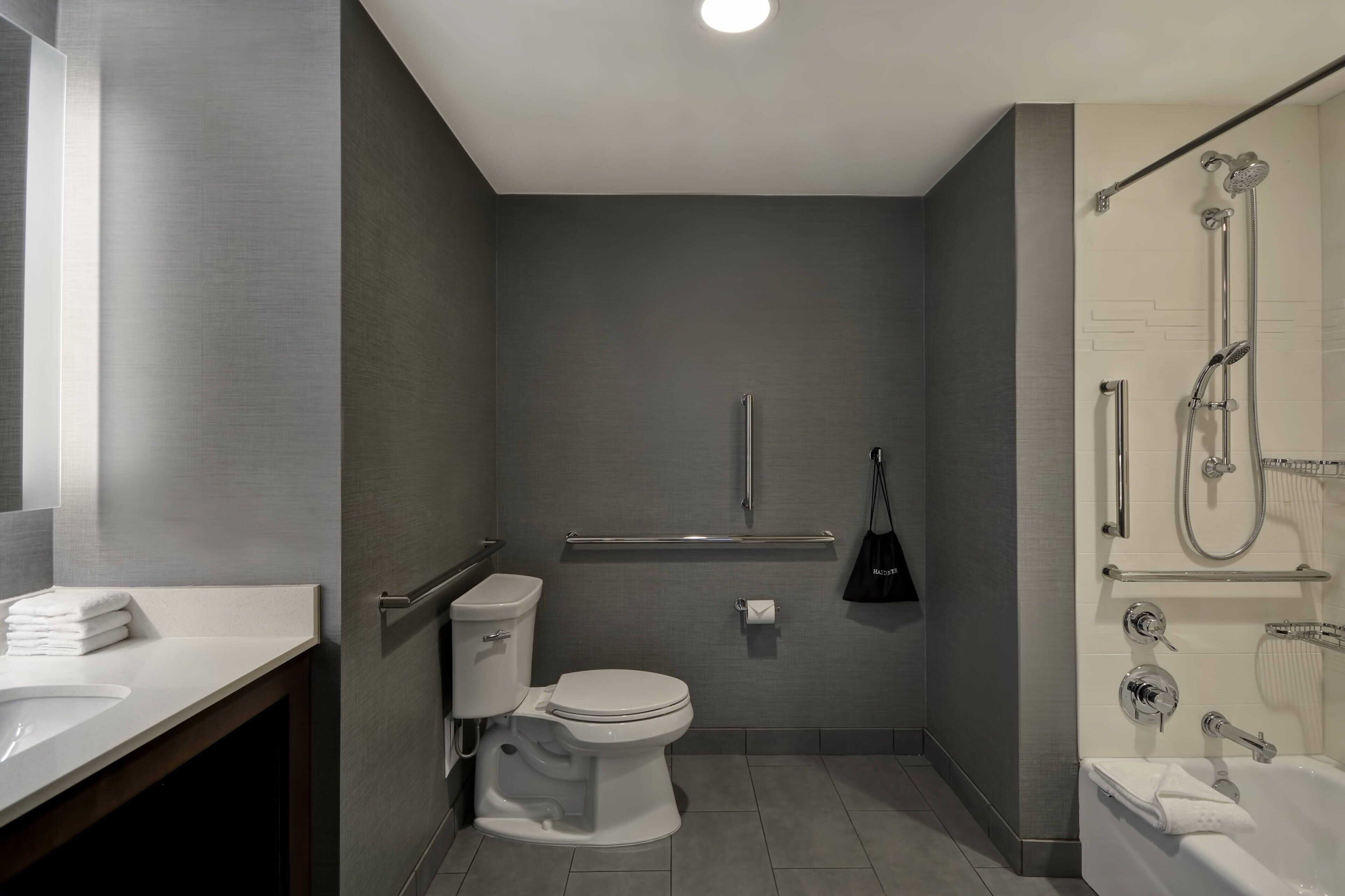 A modern bathroom with a toilet, sink, and shower.
