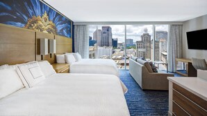 A hotel room with two beds, a sofa, a desk, and a large window with a city view. - Residence Inn by Marriott New Orleans French Quarter Area/Central Business District (New Orleans)