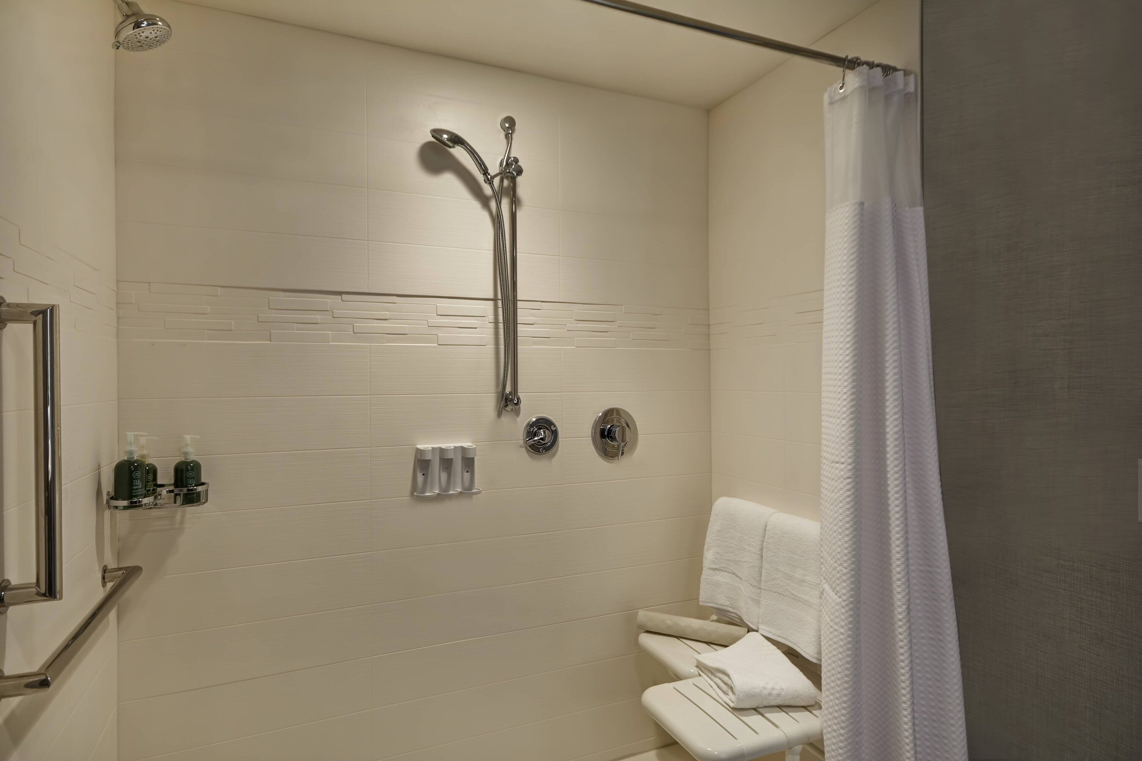 A modern bathroom with a shower, toilet, and towel rack.