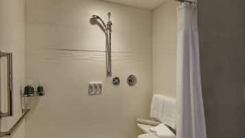 A modern bathroom with a shower, toilet, and towel rack.