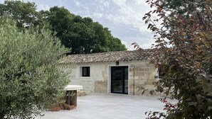 Un edificio de piedra con tejado de tejas, una puerta y una pequeña ventana.