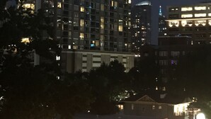A high-rise building with multiple illuminated windows at night. - Luxury Condo in Midtown area with Fast Wi-Fi (Atlanta)