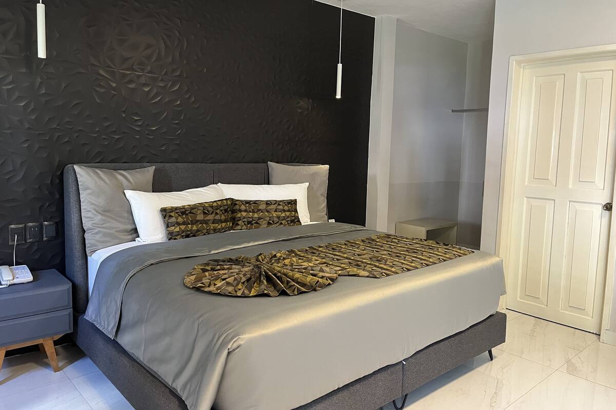 A modern bedroom with a bed, bedside table, and a wardrobe.