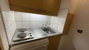 Una cocina compacta con estufa integrada, un lavamanos y lavavajillas.