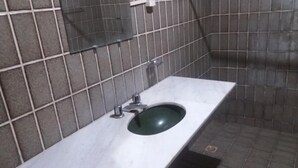 Une salle de bain avec un lavabo en marbre, des murs carrelés et un robinet en métal.