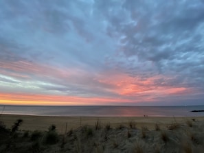 Una playa con dunas de arena y cielo nublado.