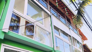 Ein zweistöckiges Gebäude mit großen Fenstern und einem Balkon.