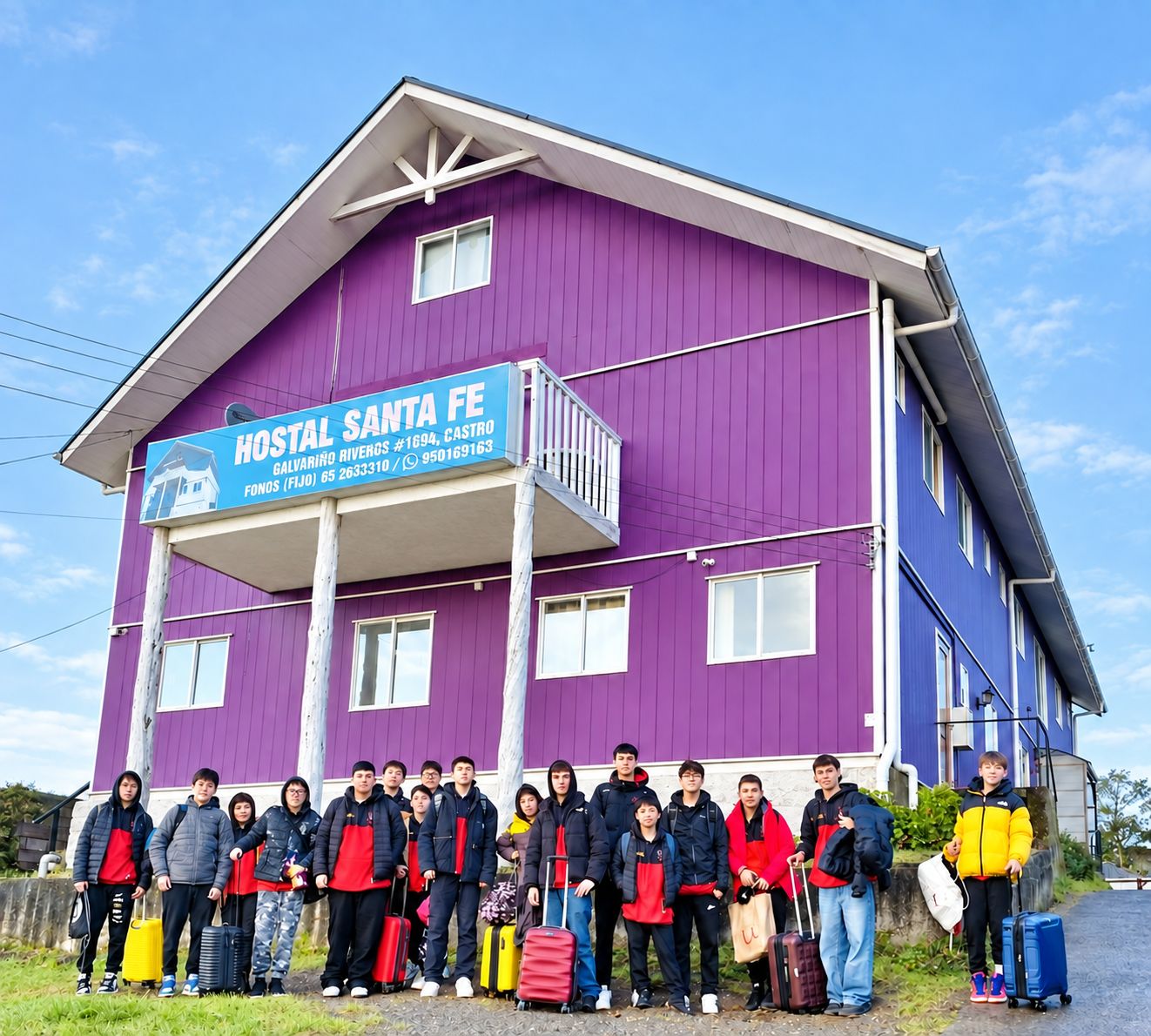 A hostel with a purple exterior and a balcony.