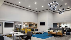 Un área de lounge moderna con asientos, una barra y un televisor.