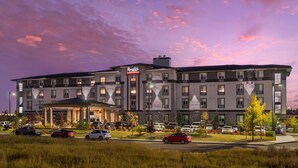 A multi-story hotel with a central entrance, parking lot, and a clear view of the sky. - Executive Residency by Best Western Calgary City View North (Calgary)