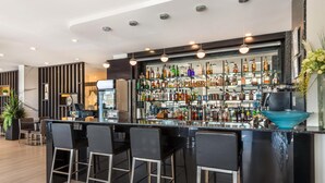 A modern bar area with a black countertop, bar stools, and a variety of liquor bottles. - Executive Residency by Best Western Calgary City View North (Calgary)