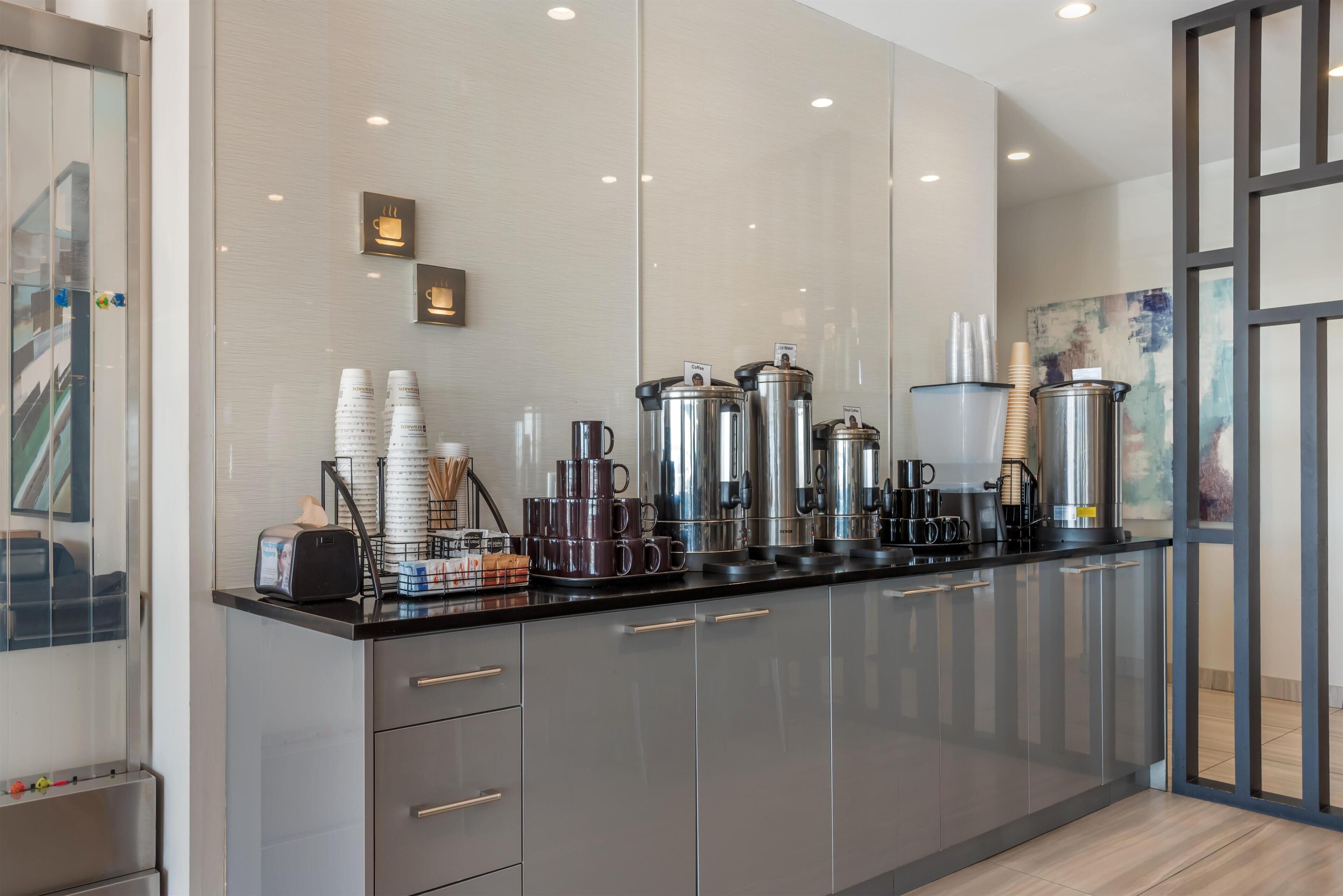 Una cocina moderna con electrodomésticos de acero inoxidable, una estación de café y vistas a la ciudad.