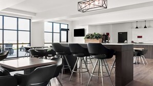 Una cocina moderna con una isla central, taburetes de bar y un amplio ventanal que proporciona luz natural.