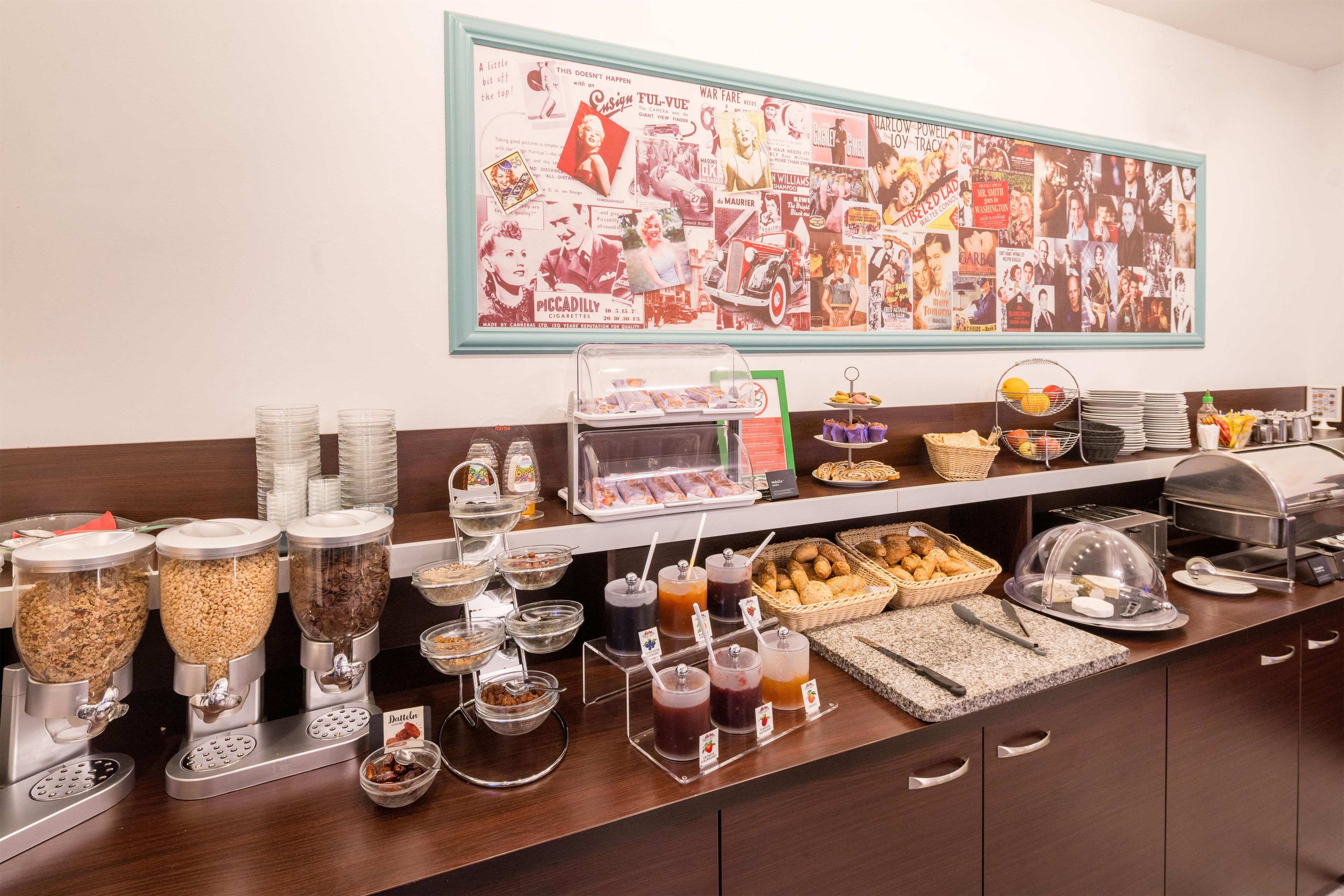 A breakfast buffet with various food items and a wall with vintage movie posters.