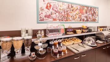 Un buffet de petit-déjeuner proposant une variété de plats et un mur décoré d’affiches de films anciens.