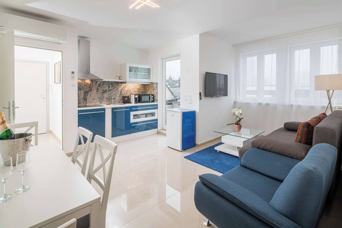 A modern apartment with a kitchen, dining area, and living room.