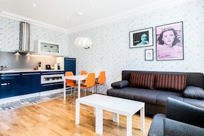 A modern living room with a grey sofa, a white coffee table, and orange chairs. - Best Western Plus Celebrity Suites (Vienna)