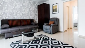 A modern living room with a sofa, armchair, and a glass coffee table. - Best Western Plus Celebrity Suites (Vienna)