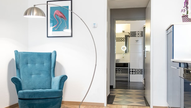 A room with a blue armchair, a floor lamp, and a framed picture on the wall. - Best Western Plus Celebrity Suites (Vienna)