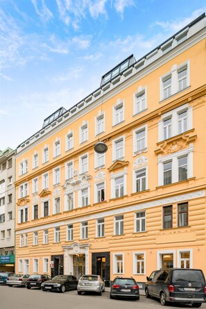 A multi-story building with a yellow facade, multiple windows, and a visible entrance with a door. - Best Western Plus Celebrity Suites (Vienna)