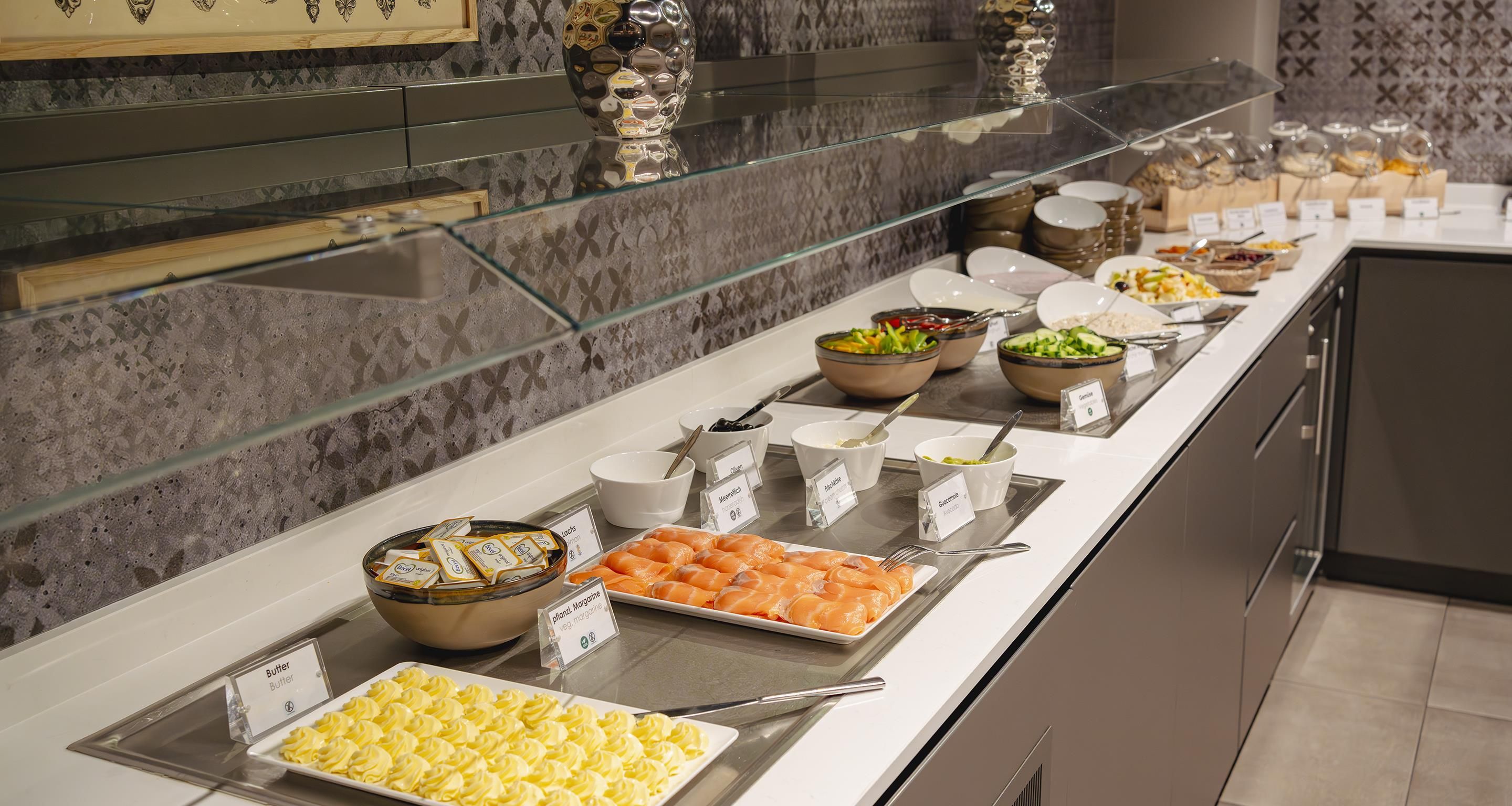 A buffet with various food items and labels.