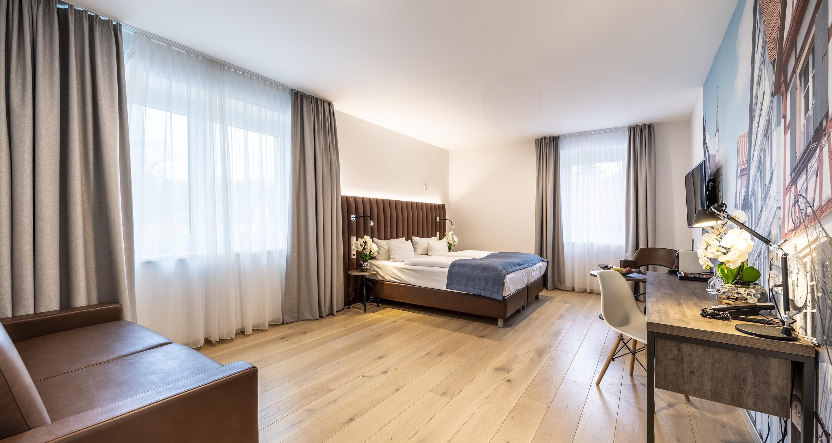 Una habitación de hotel con cama, escritorio, silla y televisión.