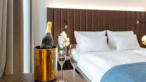 A minibar with a bottle of champagne and two glasses on a hotel bed. - Aiden by Best Western Biberach (Biberach an der Riss)