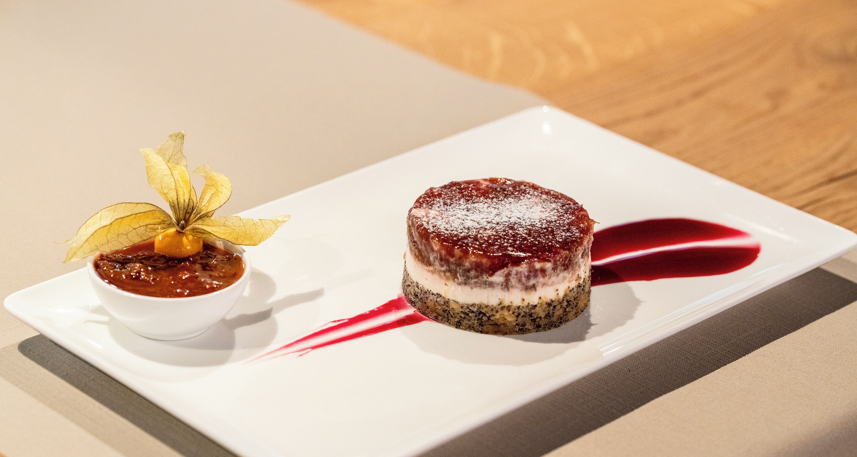 A dessert on a white plate with a red sauce.