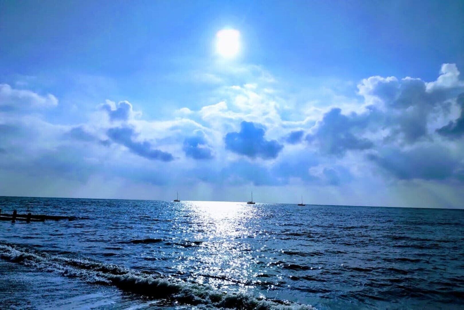 Ett lugnt hav med båtar och en klar himmel.