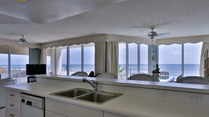 A kitchen with a large window, a sink, and a ceiling fan. - Perfect for Large Family or 2 families, Oceanfront w Ocean Views Heated Pool (New Smyrna Beach)