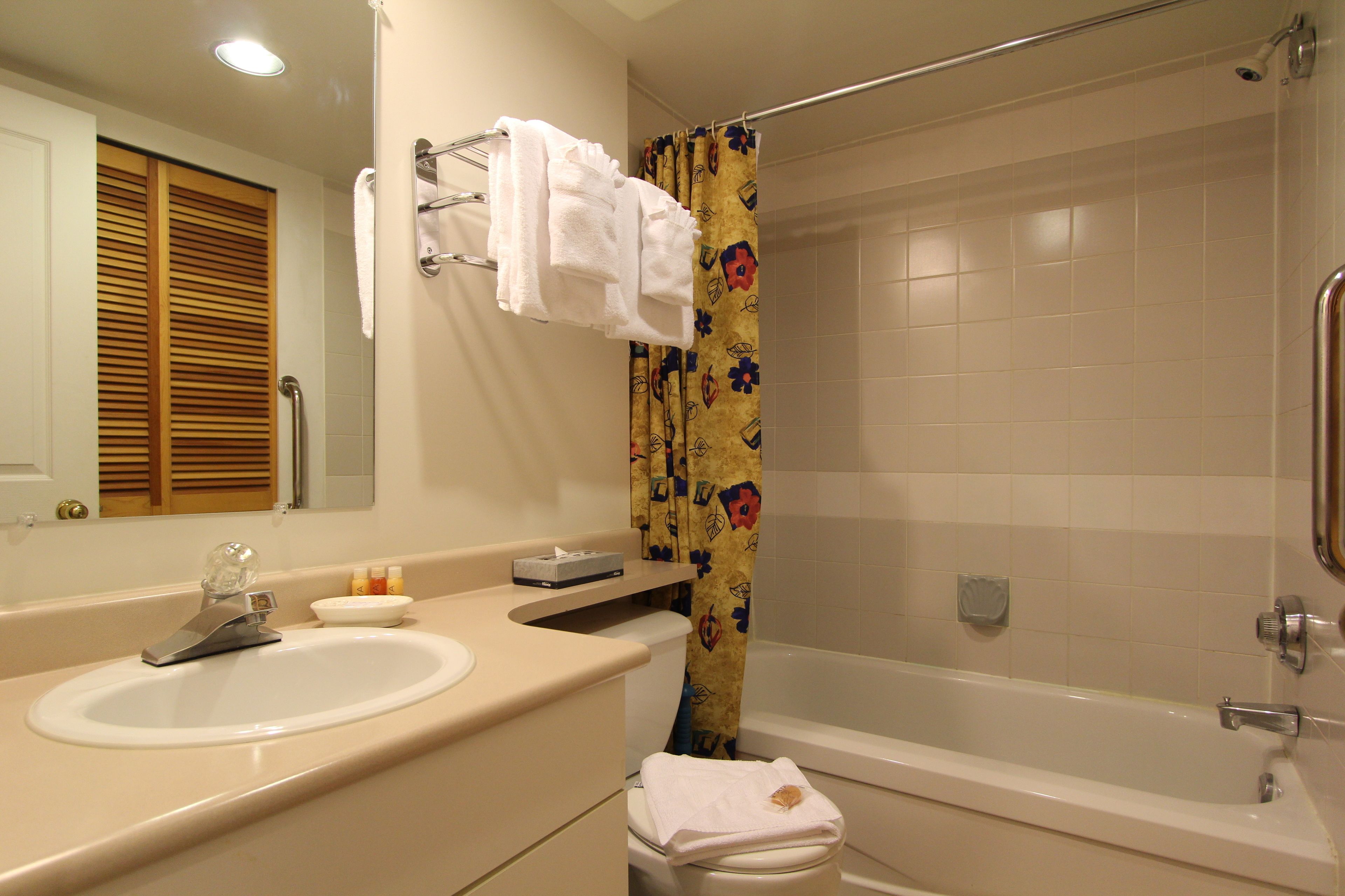 Un baño con lavamanos, espejo y bañera.