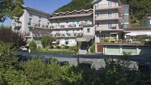 A multi-story hotel with balconies, a bar, and a pool area.