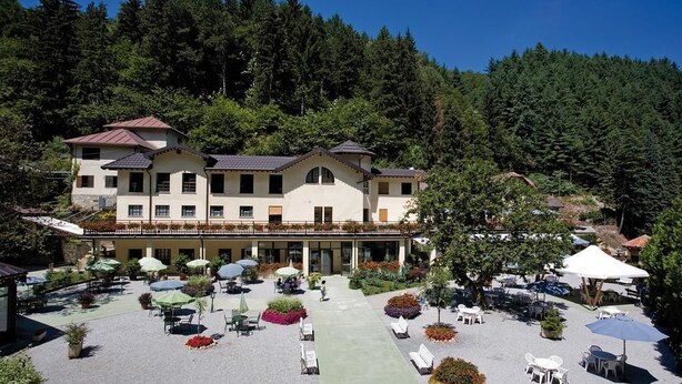 A hotel with a courtyard featuring outdoor seating and a pool area.