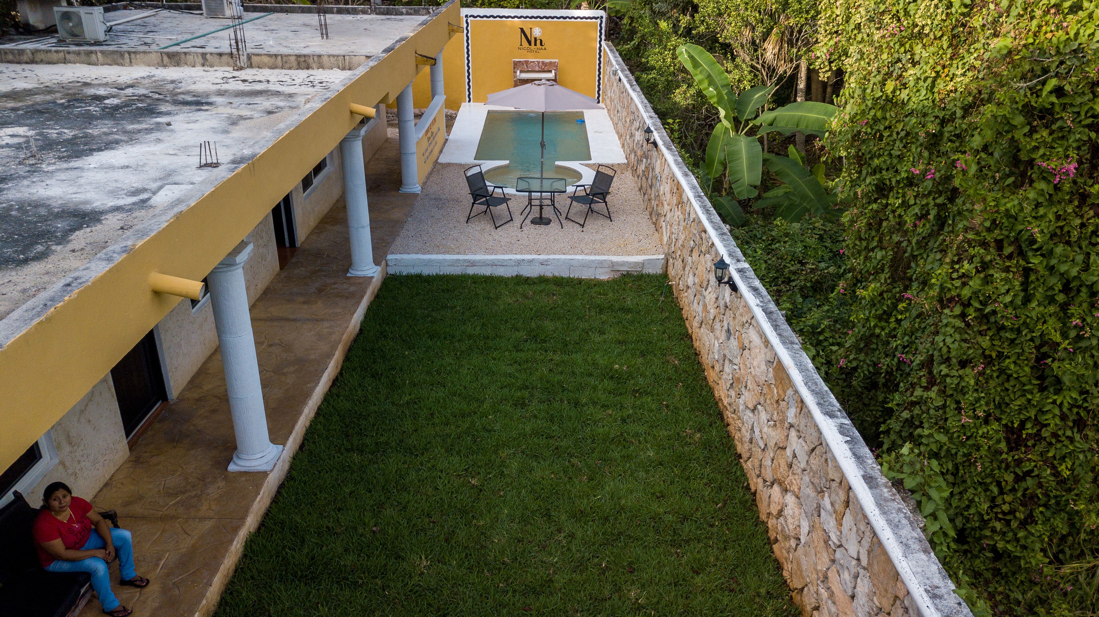 A rooftop patio with a pool table, chairs, and a small seating area.