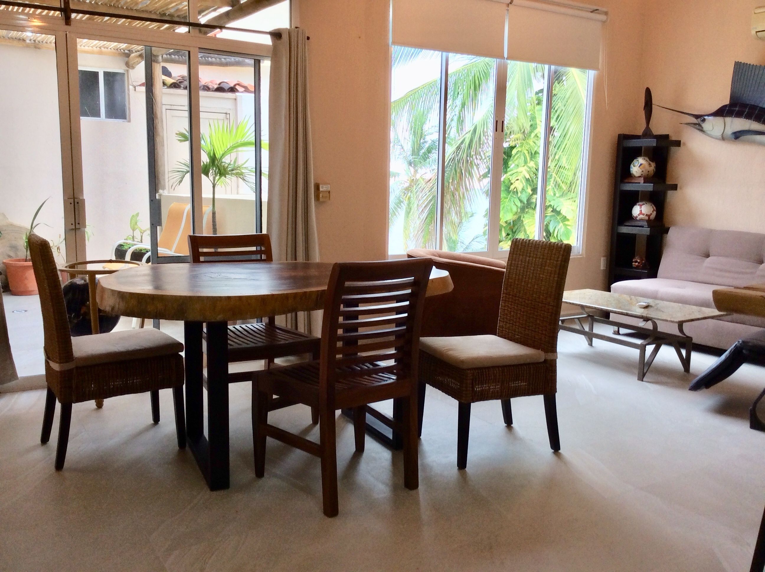 A dining area with a round table and four chairs, a sofa, and a coffee table.